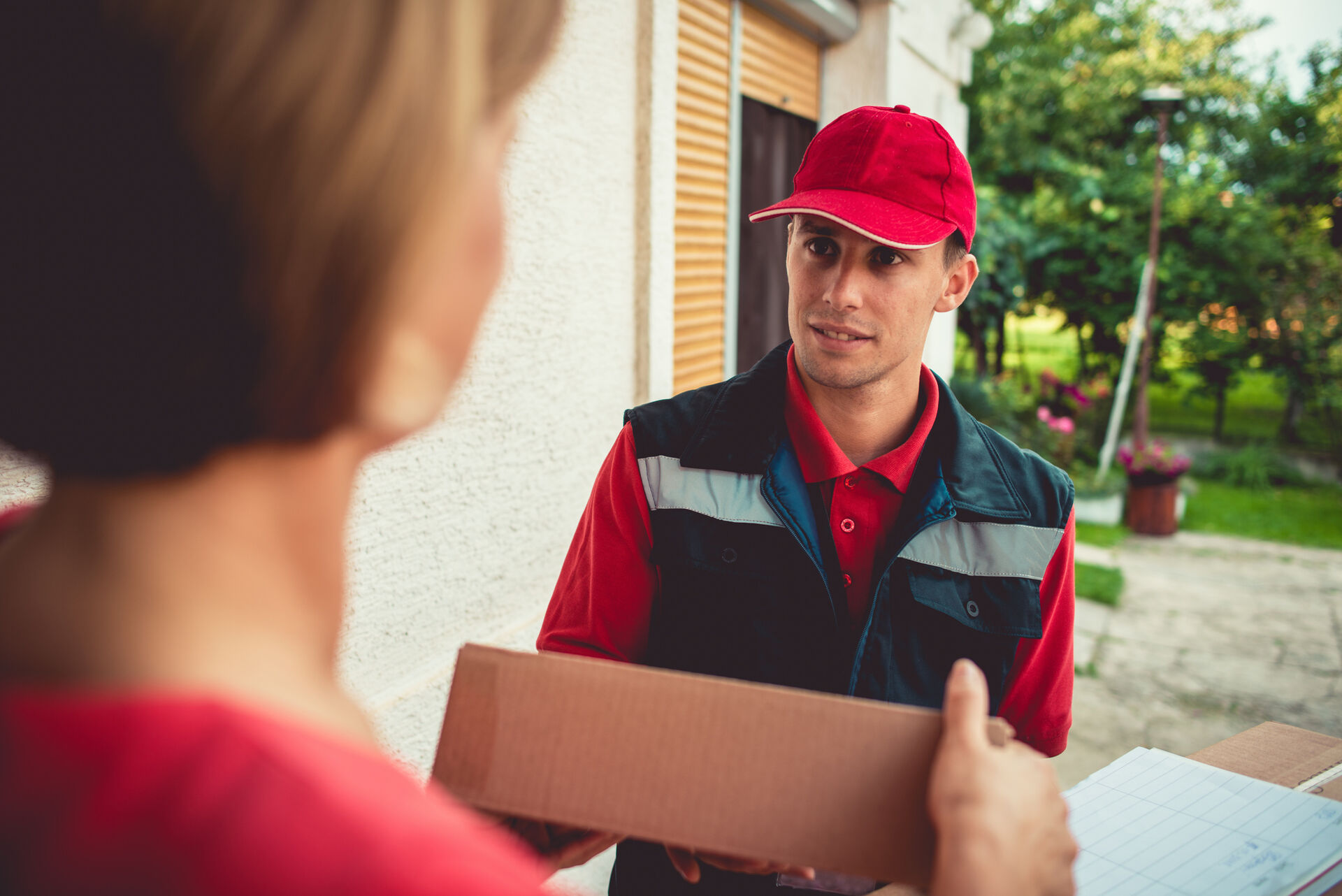 A postal carrier delivers a package.